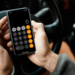 Homem usa calculadora no celular enquanto dirige carro.
