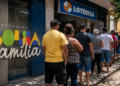 Pessoas aguardam em fila diante de uma lotérica para consultar ou receber o Bolsa Família