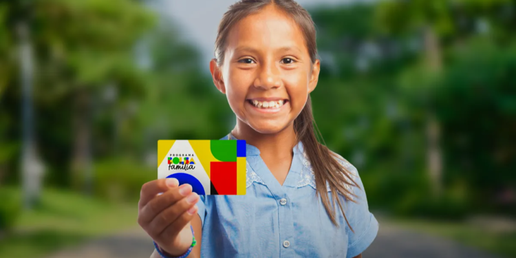 Criança sorridente exibe cartão do Bolsa Família ao ar livre em 2026.