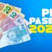 Mão segura notas de 50, 20, 10, 5 e 2 reais ao lado do texto PIS PASEP 2026 em fundo azul