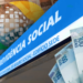Fachada da Previdência Social com notas de 100 reais em destaque.
