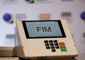 Urna eletrônica com tela exibindo “FIM” sobre teclado, indicando término da votação
