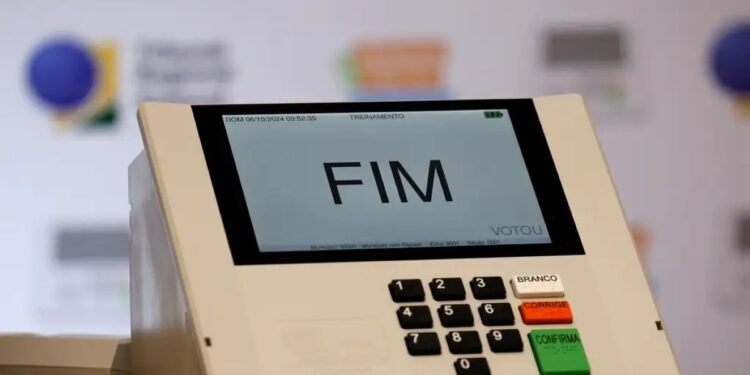Urna eletrônica com tela exibindo “FIM” sobre teclado, indicando término da votação