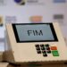 Urna eletrônica com tela exibindo “FIM” sobre teclado, indicando término da votação