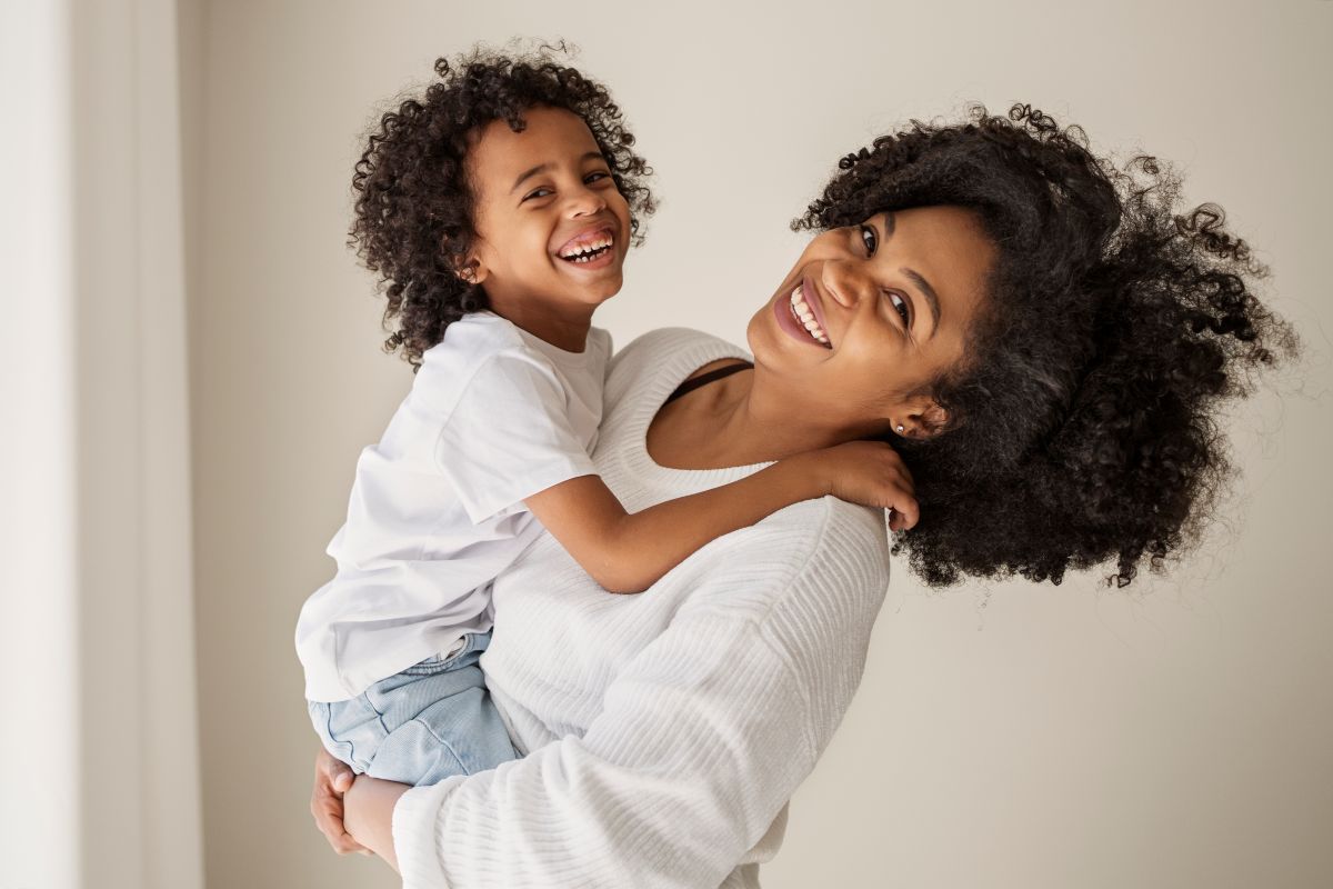 Mãe e filho sorrindo em momento de alegria e conexão.