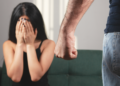 Mulher assustada sofre ameaça em situação de violência doméstica.