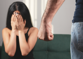Mulher assustada sofre ameaça em situação de violência doméstica.