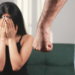 Mulher assustada sofre ameaça em situação de violência doméstica.