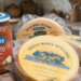 Queijo Minas Artesanal Miltião do Canastra e Pesto Rosso De Cecco em ambiente rústico.
