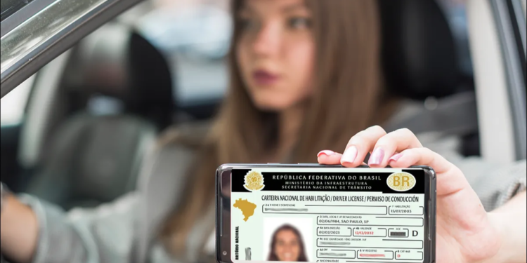 Mulher segurando celular mostrando a CNH enquanto dirige.