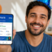 Homem sorrindo de chapéu azul segura celular mostrando saldo do FGTS em app Caixa, balões e bolo ao fundo