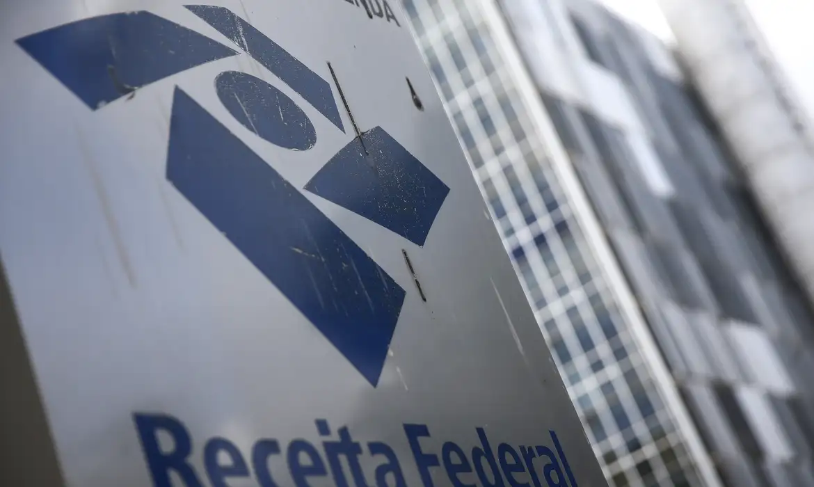 Placa com a logo da Receita Federal em frente ao prédio do órgão, que abre a consulta ao cashback do IR