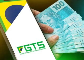 Celular com a logomarca do FGTS ao lado de cédulas de 100 reais, arte sobre a divisão de R$ 13,2 bilhões do lucro do fundo entre os trabalhadores