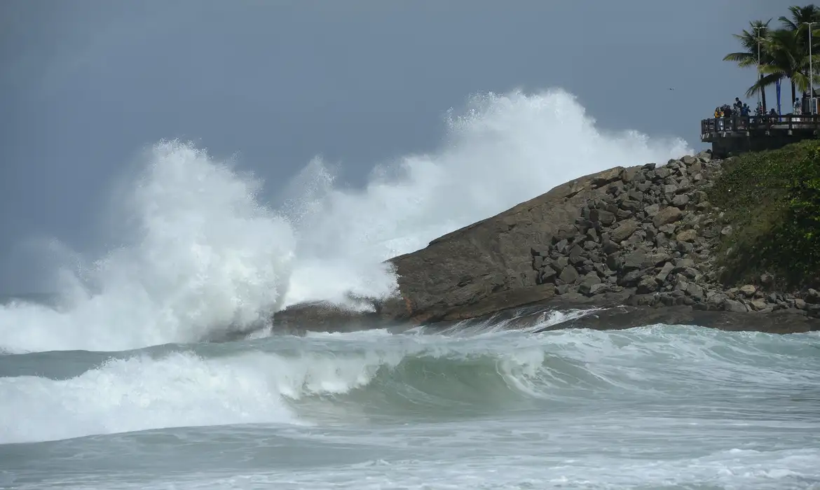 Ondas fortes se quebram sobre as pedras durante ressaca no mar, representando o aquecimento do oceano ligado ao El Niño