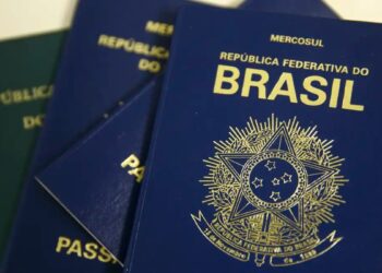 Imagem ilustrativa de passaportes brasileiros de capa azul com o brasão da República e a inscrição Mercosul, empilhados sobre uma superfície clara, cena usada para tratar da taxa, do prazo e dos documentos exigidos para a emissão do passaporte em 2026