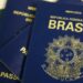 Imagem ilustrativa de passaportes brasileiros de capa azul com o brasão da República e a inscrição Mercosul, empilhados sobre uma superfície clara, cena usada para tratar da taxa, do prazo e dos documentos exigidos para a emissão do passaporte em 2026