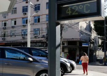 Termômetro de rua marca 42°C em uma via movimentada, ilustrando as ondas de calor associadas ao El Niño de 2026