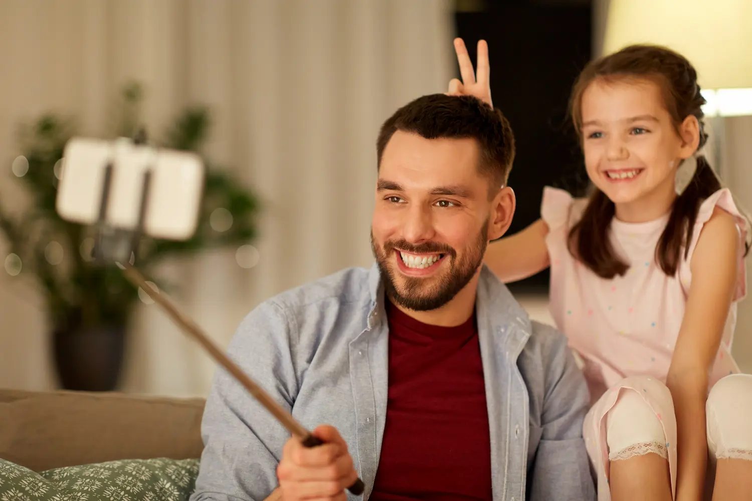 Pai e filha durante gravação de conteúdo digital sobre exposição de crianças na internet.