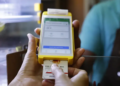 Cliente insere cartão de vale-alimentação em maquininha amarela durante pagamento em estabelecimento comercial