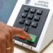 Eleitor pressiona a tecla confirma da urna eletrônica, em referência às regras de quem vota fora do domicílio eleitoral em 2026