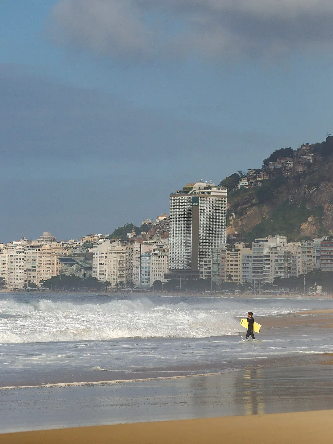 Praticante de bodyboard entra no mar agitado de Copacabana durante a ressaca provocada pela frente fria no RJ, com ondas de até 3 metros previstas pela Marinha