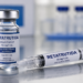 Frasco e seringa de Retatrutida 10mg/1mL sobre superfície metálica com fundo desfocado de frascos