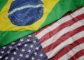 Bandeiras do Brasil e dos Estados Unidos lado a lado, representando a tensão comercial após o tarifaço de 25% sobre produtos brasileiros