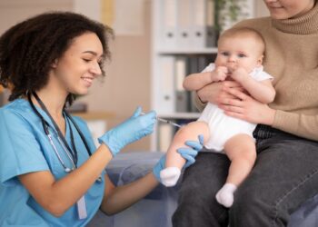 Enfermeira aplica vacina contra a gripe em bebê no colo da mãe, após a Anvisa registrar a vacina trivalente Fluprevli para uso a partir dos 6 meses de idade