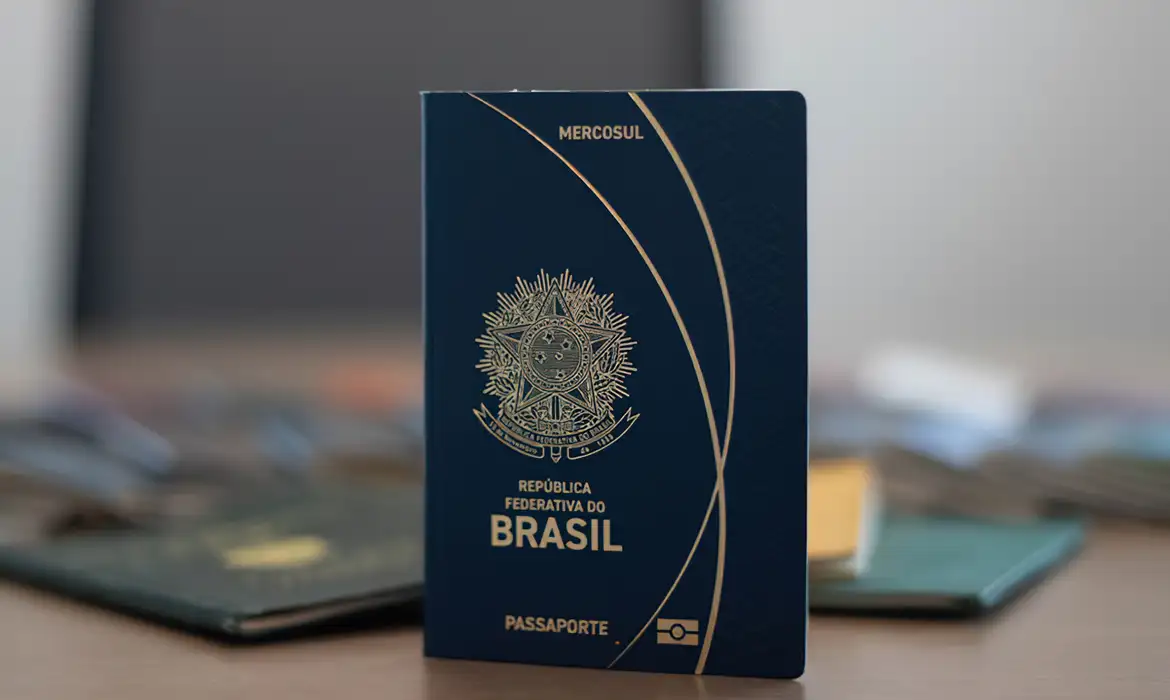 Imagem ilustrativa de passaporte brasileiro fechado, apoiado sobre mesa, em referência ao valor cobrado para emissão do documento