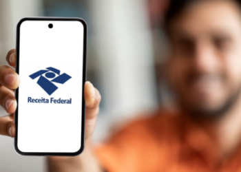 Homem exibe logo da Receita Federal em celular destacando acesso digital ao órgão.