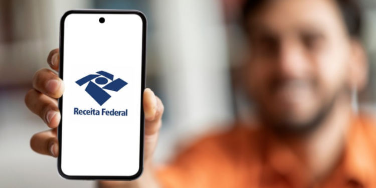 Homem exibe logo da Receita Federal em celular destacando acesso digital ao órgão.