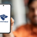 Homem exibe logo da Receita Federal em celular destacando acesso digital ao órgão.