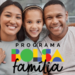 Casal adulto e criança sorrindo juntos em sofá, com logo colorida do Bolsa Família.