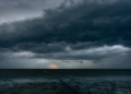 Nuvens de tempestade pesadas avançam sobre o mar ao entardecer.