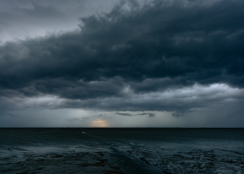 Nuvens de tempestade pesadas avançam sobre o mar ao entardecer.