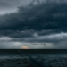 Nuvens de tempestade pesadas avançam sobre o mar ao entardecer.