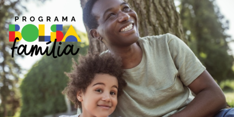 Homem e criança sorrindo com logo do Bolsa Família em parque arborizado.