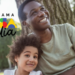 Homem e criança sorrindo com logo do Bolsa Família em parque arborizado.