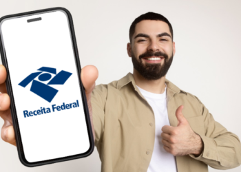 Jovem exibe logo da Receita Federal no celular com gesto de aprovação.