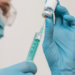 Profissional de saúde prepara seringa com vacina.
