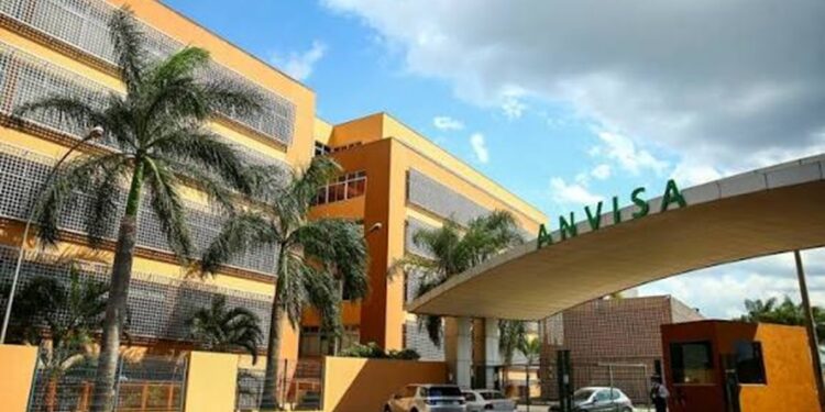 Fachada do prédio da Anvisa, a Agência Nacional de Vigilância Sanitária, com o letreiro verde na entrada, palmeiras e céu de nuvens, órgão responsável por esclarecer boatos sobre alimentos
