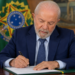 Imagem ilustrativa do presidente da República assinando documento no gabinete, ao lado da bandeira nacional, em referência ao anúncio sobre o fim da taxa das blusinhas nas compras internacionais