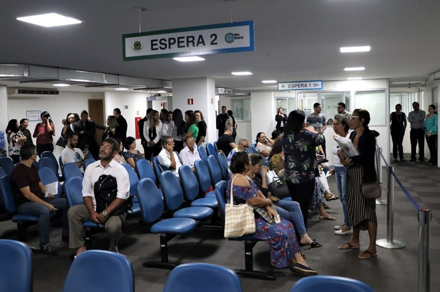 Fila de pessoas aguardando atendimento dentro de uma agência da Previdência Social.