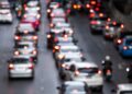 Imagem ilustrativa de trânsito congestionado em avenida, com fileiras de veículos e luzes de freio acesas ao entardecer, tema da matéria sobre as novas regras da Lei Seca aprovadas pelo Contran.