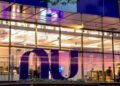 Fachada iluminada da sede do Nubank à noite, com o logotipo da instituição em destaque, em referência à liderança do banco nas renegociações do Novo Desenrola