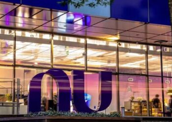 Fachada iluminada da sede do Nubank à noite, com o logotipo da instituição em destaque, em referência à liderança do banco nas renegociações do Novo Desenrola
