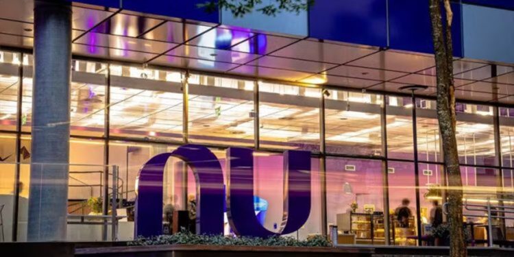Fachada iluminada da sede do Nubank à noite, com o logotipo da instituição em destaque, em referência à liderança do banco nas renegociações do Novo Desenrola