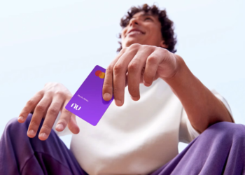 Imagem ilustrativa de homem sentado ao ar livre segurando um cartão de crédito roxo do Nubank, em referência ao Novo Desenrola Brasil 2026 e à recuperação do limite após a renegociação