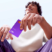 Imagem ilustrativa de homem sentado ao ar livre segurando um cartão de crédito roxo do Nubank, em referência ao Novo Desenrola Brasil 2026 e à recuperação do limite após a renegociação