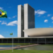 Fachada do Congresso Nacional com a bandeira do Brasil hasteada em primeiro plano, em imagem ligada à aprovação do projeto que dá prioridade no Bolsa Família a vítimas de violência doméstica.
